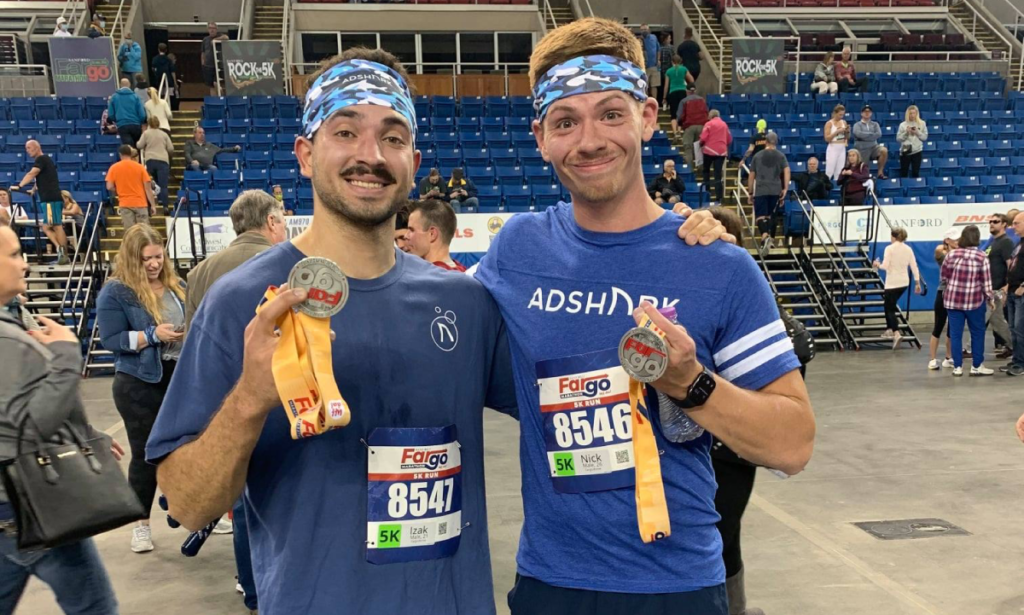 Creative Manager Nick Due and Digital Creative Designer Izak Moleterno receving their medals after finishing the Fargo 5K in Fargo, North Dakota. 